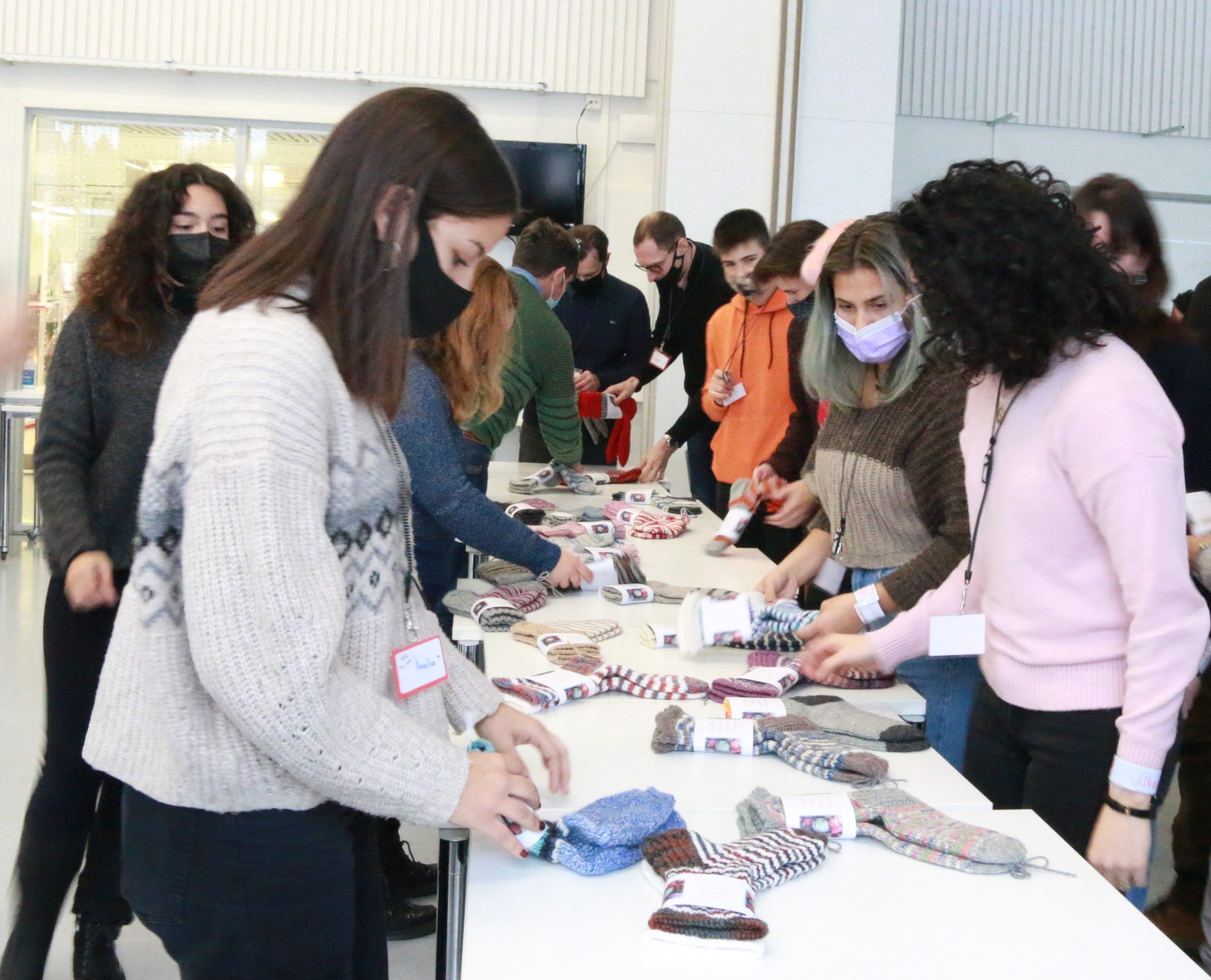 Valkeakosken ammattiopisto, VAAO, kansainväliset opiskelijavieraat valitsemassa villasukkia pöydän ympärillä