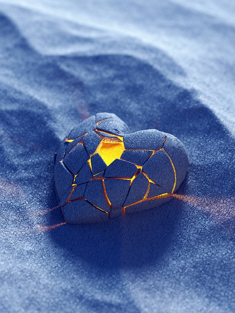 Valkeakosken ammattiopisto, VAAO, sininen sydän, josta loistaa valo, sinisävyisellä hiekalla.