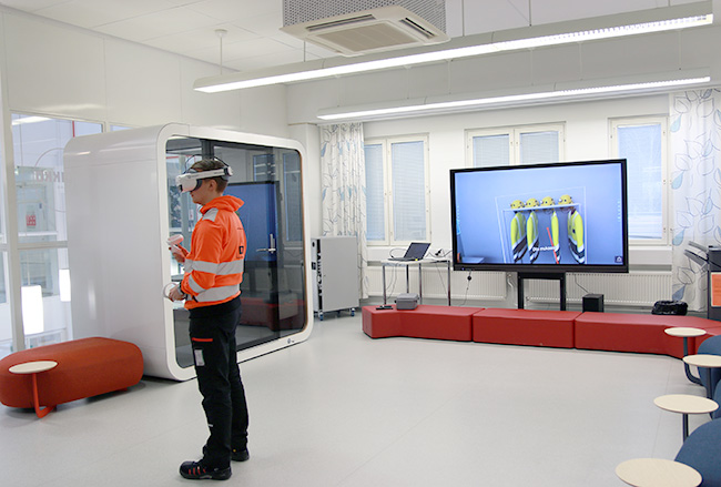Valkeakosken ammattiopisto, VAAO, henkilö seisoo ja kokeilee virtuaalilaseja avoimessa tilassa.