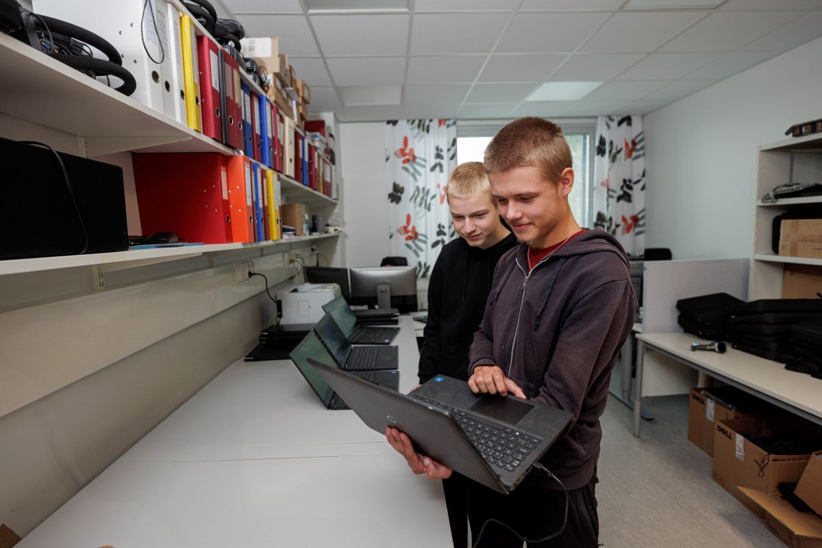 Kaksi VAAOn ICT-alan opiskelijaa tutkii kannettavan tietokoneen näytöltä päivitystä.