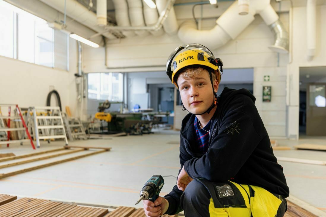 Rakennusalan opsikelija VAAOn työsalissa pora kädessään.