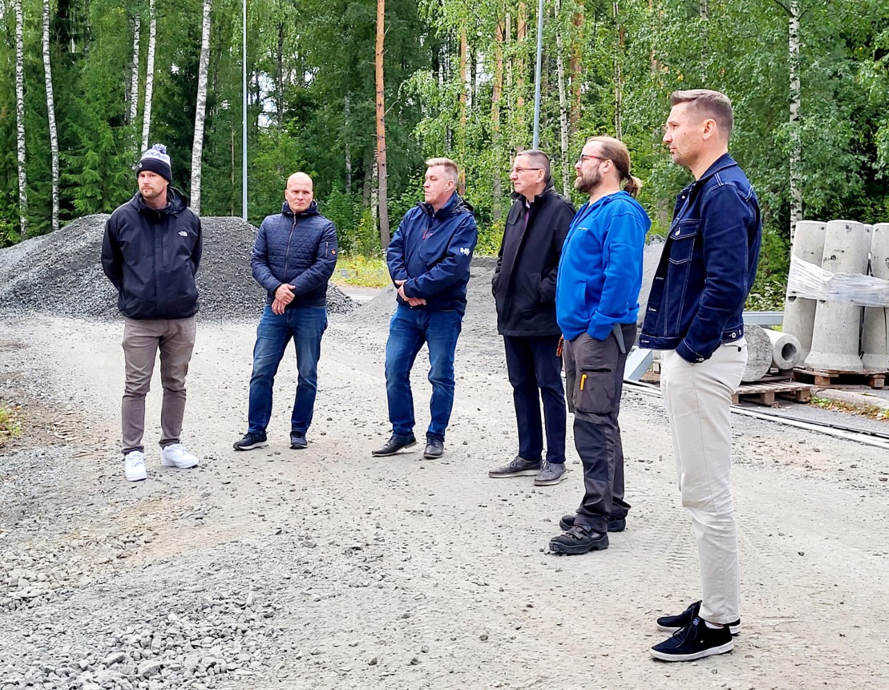 Valkeakosken ammattiopisto, VAAO, Kuusi henkilöä seisoo työmaalla ja katselee pump track-radalle päin.